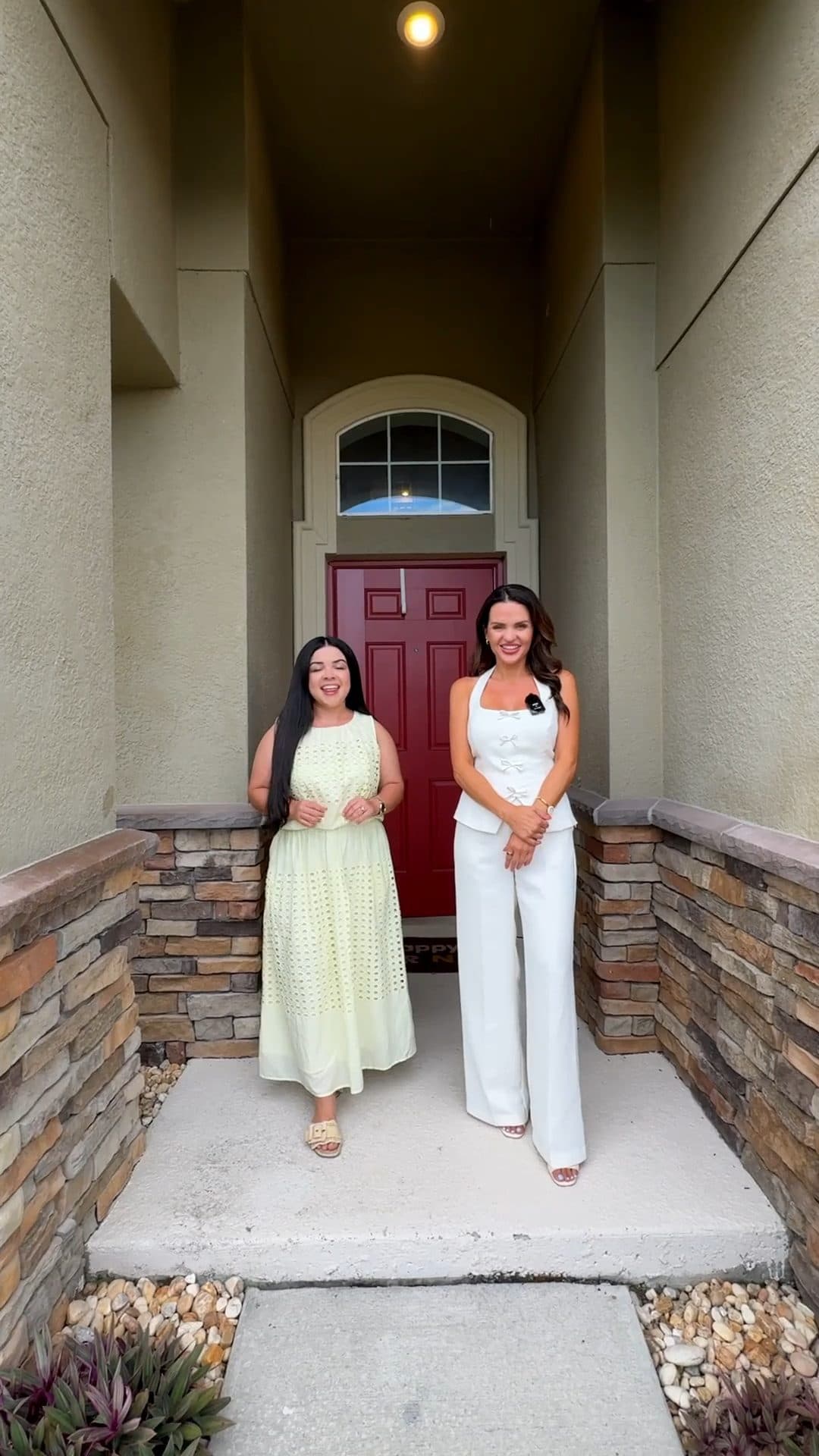 Luana and Nelly at the red front door of 3853 Cortland Dr, a still from the video tour