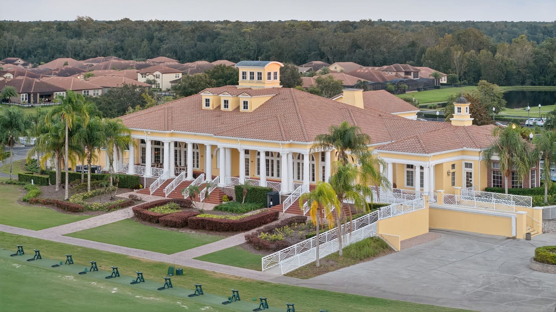 The Providence clubhouse, a two-story building with a wraparound porch and palm trees