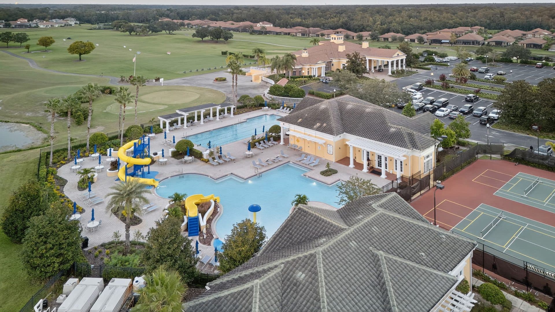 The Providence community pool with yellow and blue water slides and palm trees
